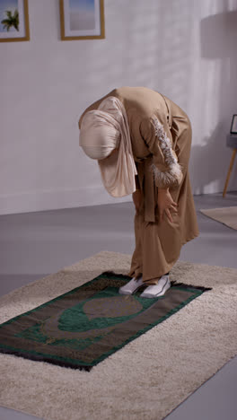 Video-Vertical-De-Una-Mujer-Musulmana-Usando-Hijab-En-Casa-Orando-Arrodillada-Sobre-Una-Alfombra-De-Oración-4